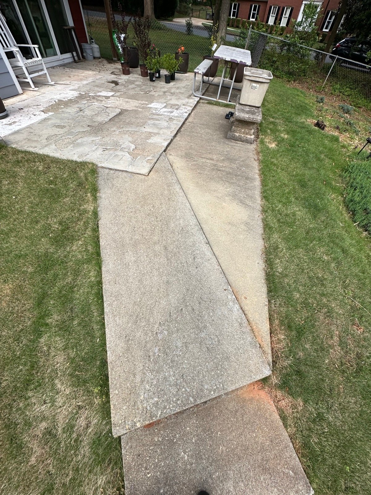 Backyard patio and walkway before cleaning, patchy and stained